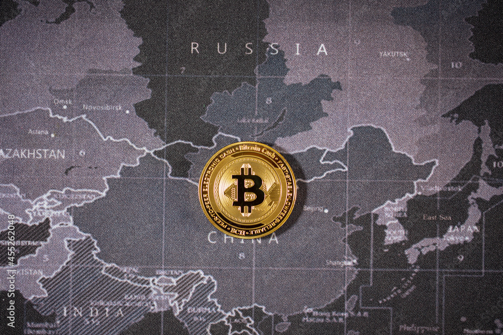 one gold bitcoin is lay on the world map over the name of country.